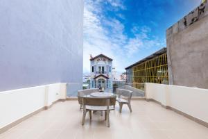 un balcone con tavolo e sedie e un edificio di The Blue Haven Vung Tau a Vung Tau