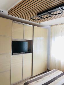 una habitación con TV de pantalla plana y una habitación con una bañera de hidromasaje en Imperium DK Apartament, en Giurgiu