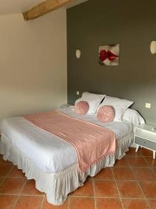 1 dormitorio con 1 cama con 2 almohadas rosas en Gite a la ferme avec jacuzzi et sauna, en Villefloure