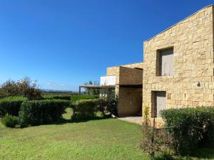 Masainas的住宿－Casa Barbara Sardinia，一座石头房子,前面有一座院子