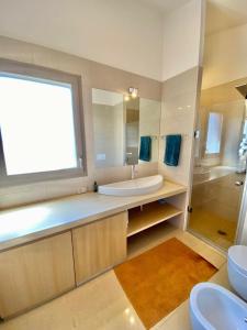 een badkamer met een bad, een wastafel en een spiegel bij Casa Barbara Sardinia in Masainas