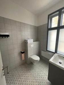 a bathroom with a toilet and a sink at Dream Apartman in Levél