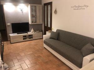 a living room with a couch and a flat screen tv at LA CASA DI ZOE in Campiglia Marittima