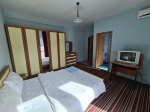 a bedroom with two beds and a tv in it at Holiday in Ferizaj