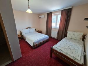 a hotel room with two beds and a window at Holiday in Ferizaj