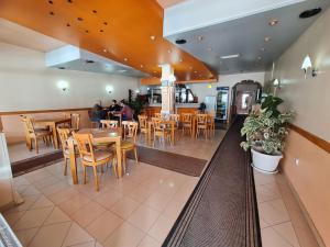 a restaurant with tables and chairs and people sitting at tables at Holiday in Ferizaj