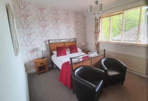 Un dormitorio con una cama con almohadas rojas y una silla en The Limes, en York