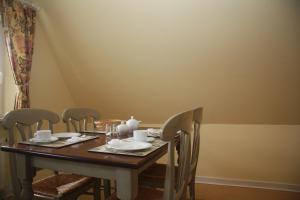 uma mesa de jantar com 4 cadeiras e uma mesa e cadeira em Reethof em Tinnum