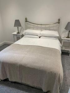 a bedroom with a large bed with two night stands at The Victorian Apartment in Dundee