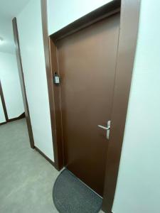 una porta marrone in una stanza con un tappeto di La pause zen a Tulle