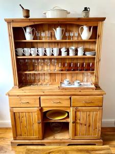Cette cabane en bois comprend des tasses et de la vaisselle. dans l'établissement Spacious 3 bedroom garden apartment in Snowdonia National Park, 