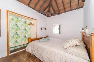a bedroom with a bed and a large painting on the wall at Casa Buganvilla in Hermigua