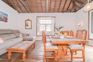 sala de estar con mesa de madera y sillas en Casa Buganvilla, en Hermigua