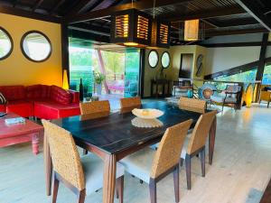 uma sala de jantar com uma mesa de madeira e cadeiras em Flamboyant Residence em Fernando de Noronha