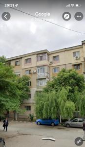 a blue car parked in front of a building at Imperium DK Apartament in Giurgiu