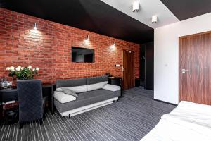 a bedroom with a couch and a brick wall at Rezydencja 