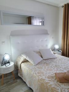 ボオ・デ・ピエラゴスにあるAlbergue Piedadのベッドルーム1室(ベッド1台、テーブルにランプ2つ付)