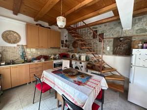 a kitchen with a table and a kitchen with a staircase at Grandma's Place in Aïdonochórion