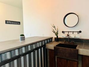 a bathroom with a sink and a mirror on the wall at Industrial stylish 3-br. apartment & city views in front of Parque Fundidora & Arena Mty in Monterrey