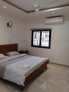 um quarto com uma cama grande e uma janela em RÉSIDENCE HÔTELIÈRE KAWEROU em Ouagadougou