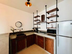 a kitchen with a refrigerator and a sink at Industrial stylish 3-br. apartment & city views in front of Parque Fundidora & Arena Mty in Monterrey