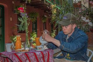 a man sitting at a table with a tea pot at Hotel Willcamayu in Pisac