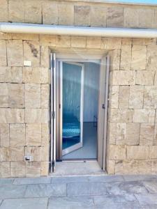eine Backsteinmauer mit einer Tür in ein Gebäude in der Unterkunft Casa Barbara Sardinia in Masainas