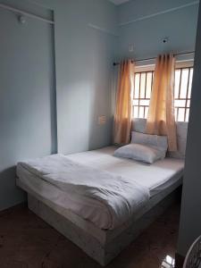 Cama grande en habitación con 2 ventanas en Kamadhenu Residency Homestay Hotel Coorg Madikeri, en Madikeri