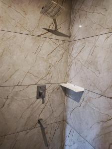 a shower with a stone wall in a bathroom at Kamadhenu Residency Homestay Hotel Coorg Madikeri in Madikeri