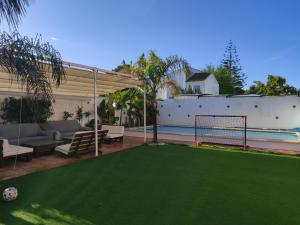 un patio trasero con una pelota de fútbol en la hierba en Apartamento privado con piscina y jardin compartidos., en Valencina de la Concepción