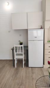 a kitchen with a white refrigerator and a table at Lovely studio with balcony in Rechovot