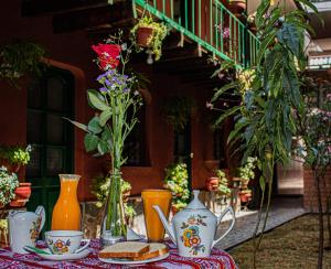 un tavolo con vasi, panini e fiori sopra di Hotel Willcamayu a Písac