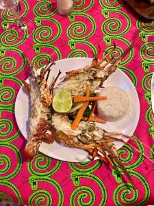 a plate of food with shrimp and carrots and rice at Maison Couleur Passion in Nianing