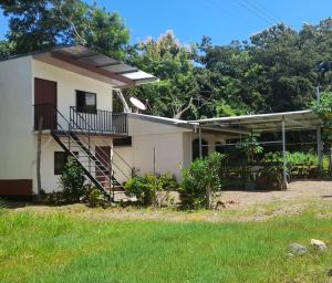 una casa con una escalera frente a un patio en Cabinas Playa Agujas, en Quebrada Ganado