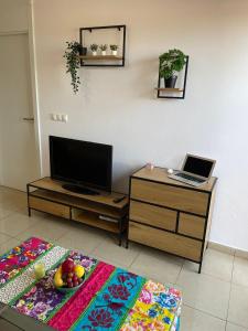 ein Wohnzimmer mit einem TV und einem Tisch mit einem Laptop in der Unterkunft Casa Palmera - El Bosque - Playa Flamenca in Playa Flamenca