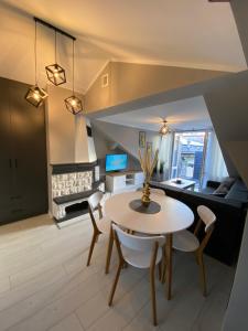 a living room with a table and chairs and a couch at Apartament Jarosław in Jarosław