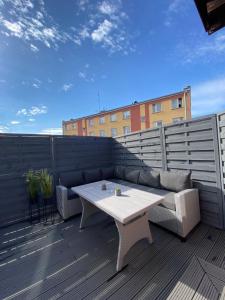a patio with a couch and a table on a deck at Apartament Jarosław in Jarosław