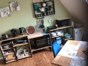 a kitchen with a table and a microwave at Chambre studio familiale la Brandonnière in Courson
