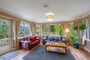 a living room with a couch and a table at Wildwood Cottage with Hot Tub in Glencoe