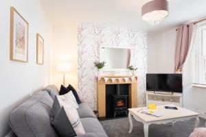 sala de estar con sofá y chimenea en *Brand New* Lemon Tree Cottage, en Torquay