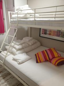 2 łóżka piętrowe z białymi ręcznikami i poduszką w obiekcie Apart T2 pied pistes Pyrénées 2000 récemment rénové w mieście Bolquere Pyrenees 2000