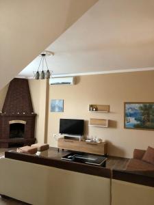 a living room with a couch and a fireplace at Sunnyside Villa in Durrës