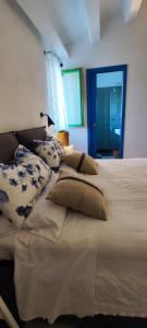 ein Schlafzimmer mit einem Bett mit Kissen und einem Fenster in der Unterkunft Casa Don Michele in Letojanni