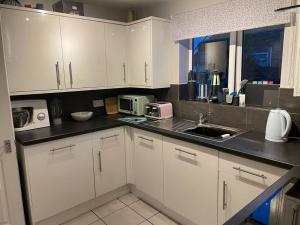 Stockton on the forestにある27 The Limes Room 1の白いキャビネットとシンクのあるキッチン
