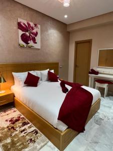 een slaapkamer met een groot bed met rode kussens bij Antonios luxury apartments in Fès