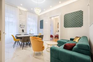 uma sala de estar com um sofá verde e uma mesa em Premium Art Deco Apartment at Broadway // 4BDR & 3BR em Budapeste