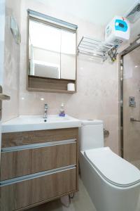 een badkamer met een toilet, een wastafel en een spiegel bij White Beach Holiday in Hulhumale