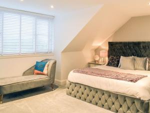 a bedroom with a bed and a chair at Baileyfield Cottage in Edinburgh