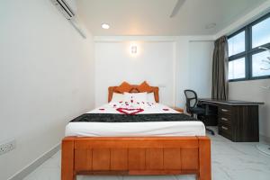 a bedroom with a bed and a desk in it at White Beach Holiday in Hulhumale