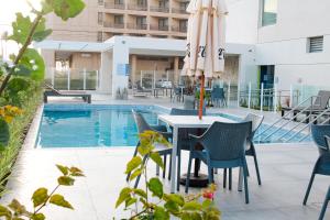 a patio with a table and chairs and an umbrella at ibis budget Aracaju in Aracaju